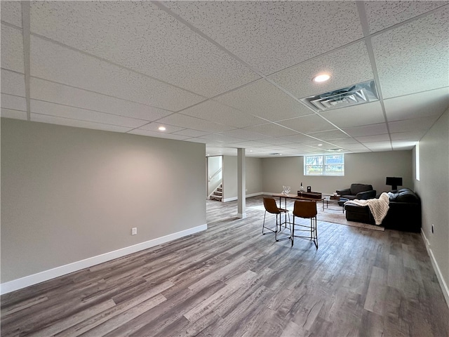 basement featuring wood-type flooring and a drop ceiling