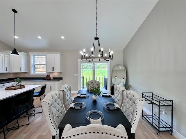 dining space with light hardwood / wood-style floors, vaulted ceiling, and a notable chandelier