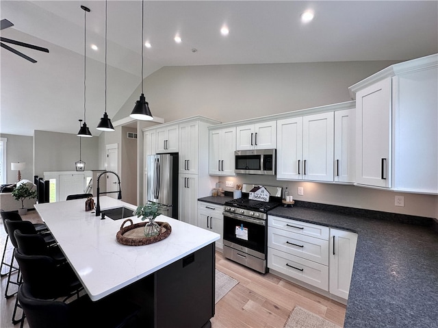 kitchen featuring sink, hanging light fixtures, light hardwood / wood-style floors, white cabinetry, and stainless steel appliances