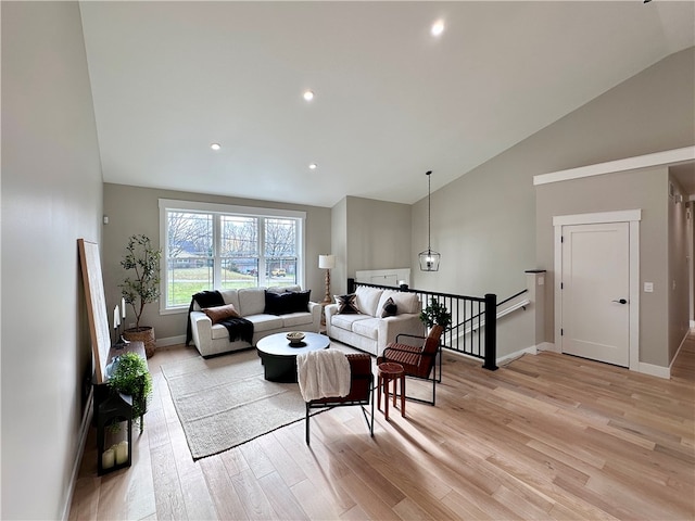 living room featuring light wood-type flooring and high vaulted ceiling