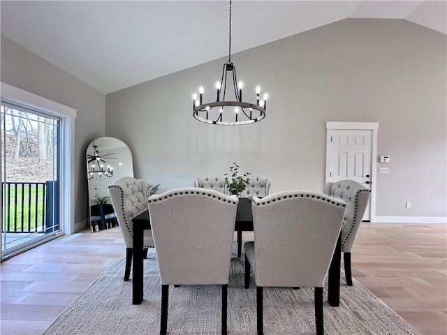 dining area with light hardwood / wood-style flooring, ceiling fan with notable chandelier, and lofted ceiling