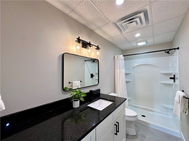 bathroom with vanity, toilet, a drop ceiling, and curtained shower