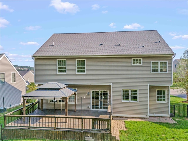 rear view of property featuring a gazebo, a patio area, and a lawn