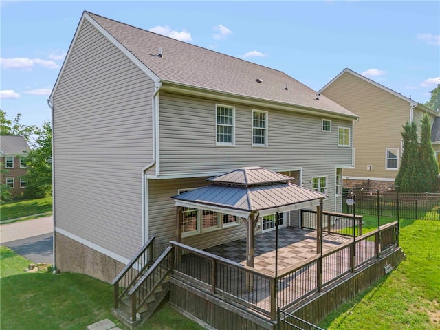 back of property with a gazebo and a lawn