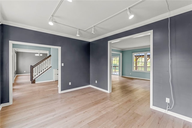 spare room featuring crown molding, light hardwood / wood-style flooring, and track lighting