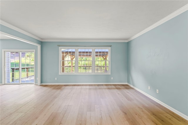 spare room with light wood-type flooring and ornamental molding