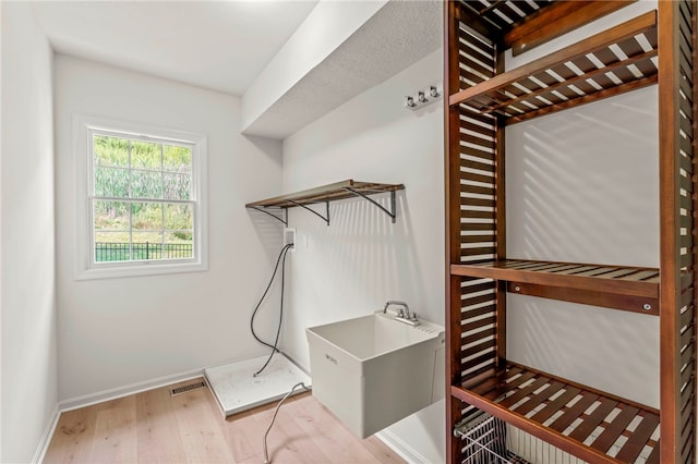 clothes washing area featuring light hardwood / wood-style flooring