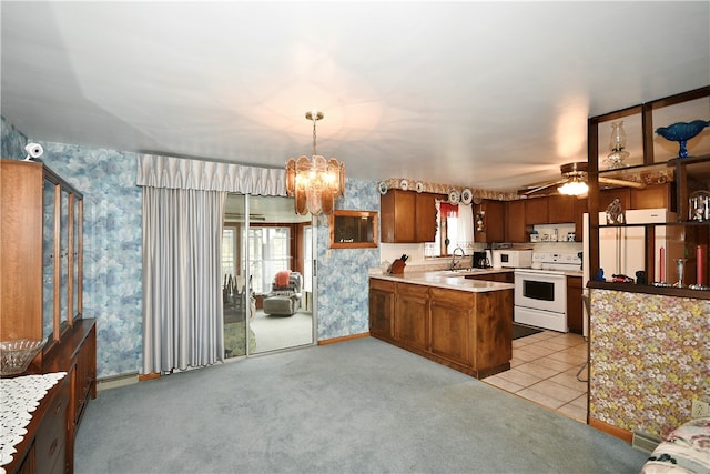 kitchen with kitchen peninsula, light carpet, white appliances, sink, and decorative light fixtures