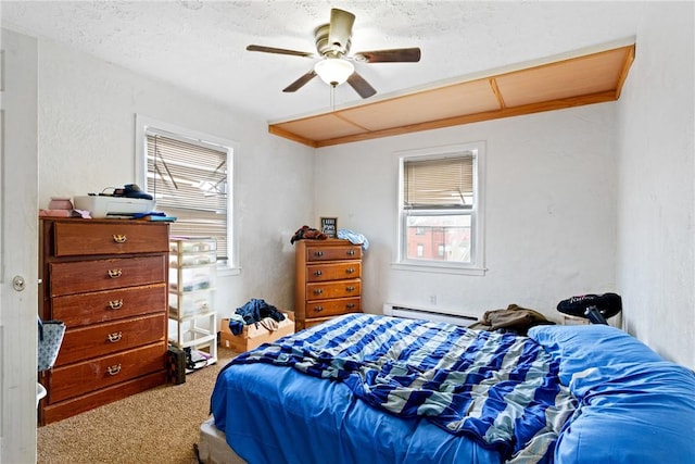 bedroom featuring carpet, a textured ceiling, ceiling fan, and a baseboard heating unit