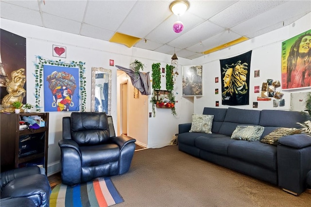 living room with a drop ceiling and carpet