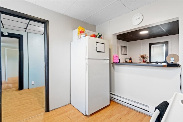 kitchen featuring a paneled ceiling, white refrigerator, light hardwood / wood-style flooring, and a baseboard heating unit