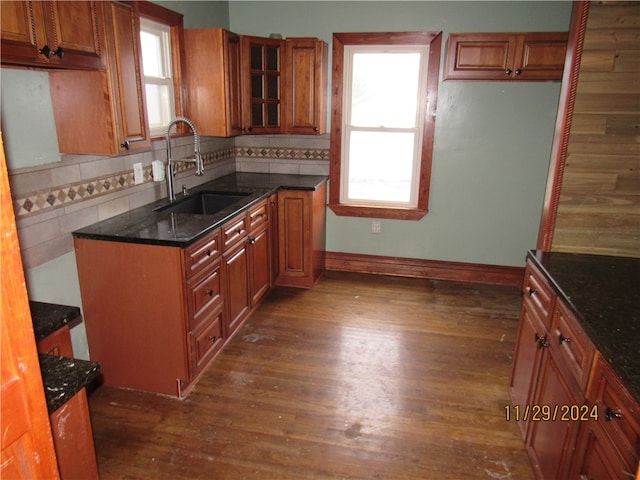 kitchen featuring tasteful backsplash, dark stone countertops, sink, and dark hardwood / wood-style floors