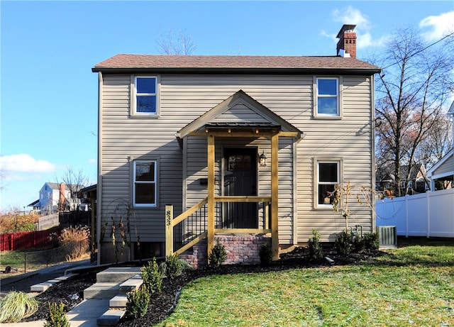 front facade with a front yard and central AC