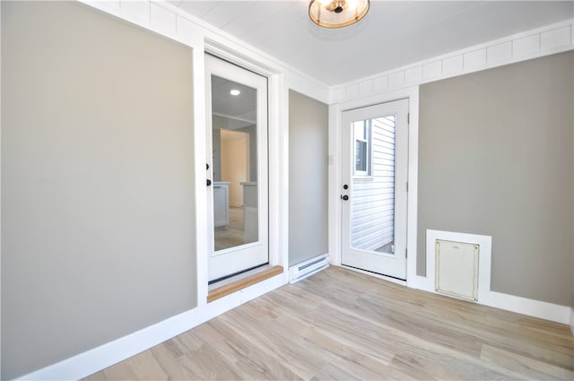 empty room featuring baseboard heating and light hardwood / wood-style flooring