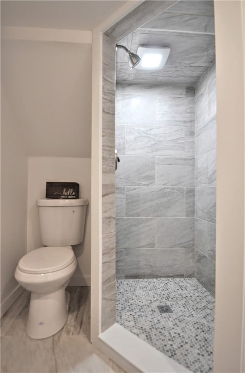 bathroom with toilet and tiled shower