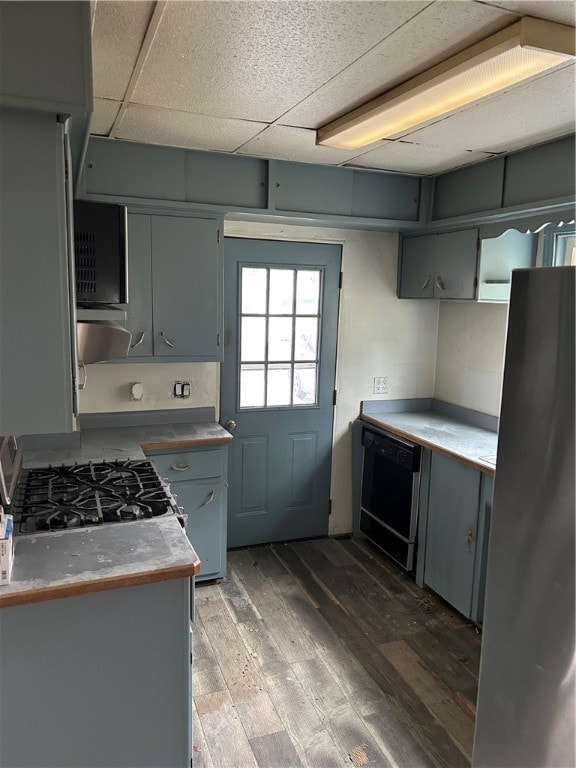 kitchen with a paneled ceiling, dark hardwood / wood-style flooring, range, and black dishwasher