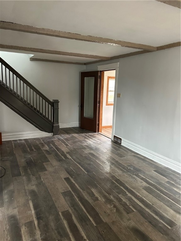 spare room with beamed ceiling and dark hardwood / wood-style floors