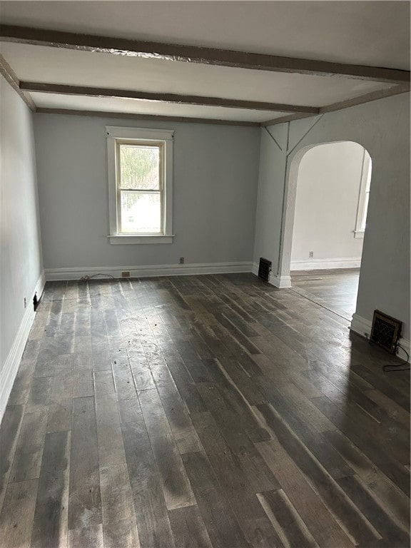 unfurnished room with beam ceiling and dark hardwood / wood-style floors