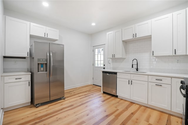 kitchen featuring white cabinets, light wood-type flooring, and stainless steel appliances