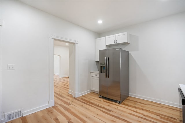 kitchen featuring stainless steel fridge with ice dispenser, white cabinets, and light wood-type flooring