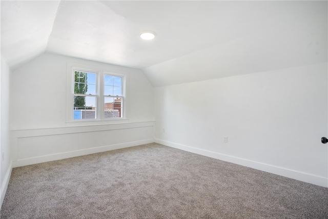 additional living space with carpet floors and vaulted ceiling