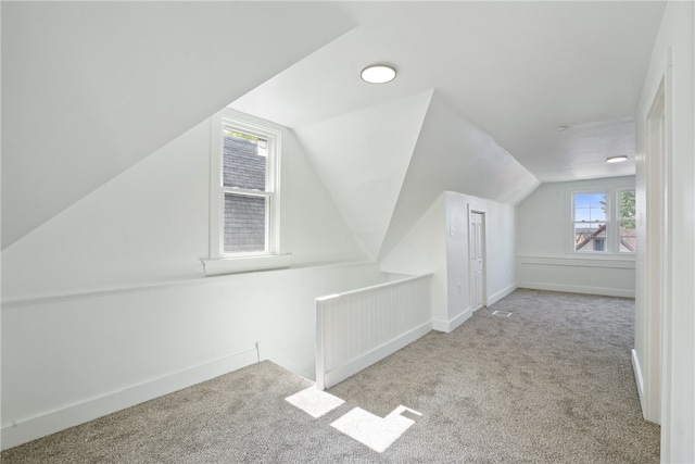 bonus room featuring lofted ceiling and light carpet