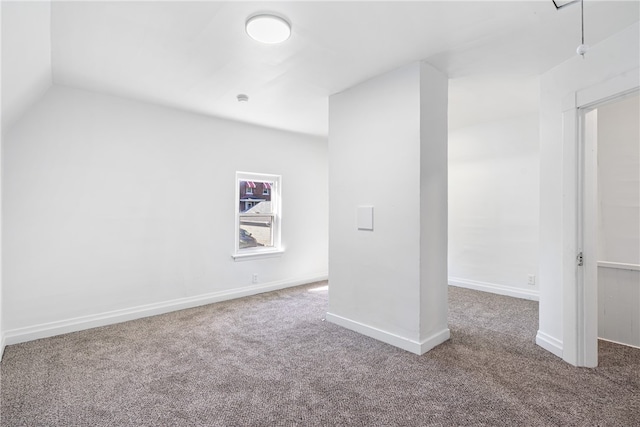 carpeted empty room with lofted ceiling