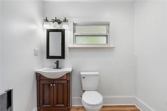 bathroom featuring vanity, wood-type flooring, and toilet