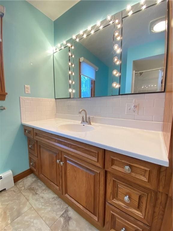 bathroom featuring baseboard heating, a shower with curtain, decorative backsplash, and vanity