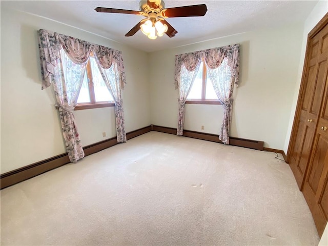 unfurnished bedroom featuring ceiling fan, a closet, and light carpet