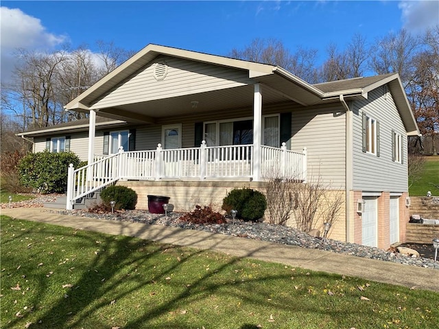 view of front of house with covered porch, a garage, and a front yard