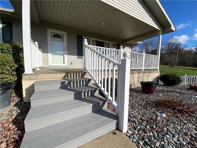 view of exterior entry featuring covered porch