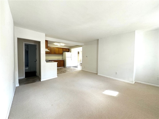 unfurnished living room featuring light carpet and a textured ceiling