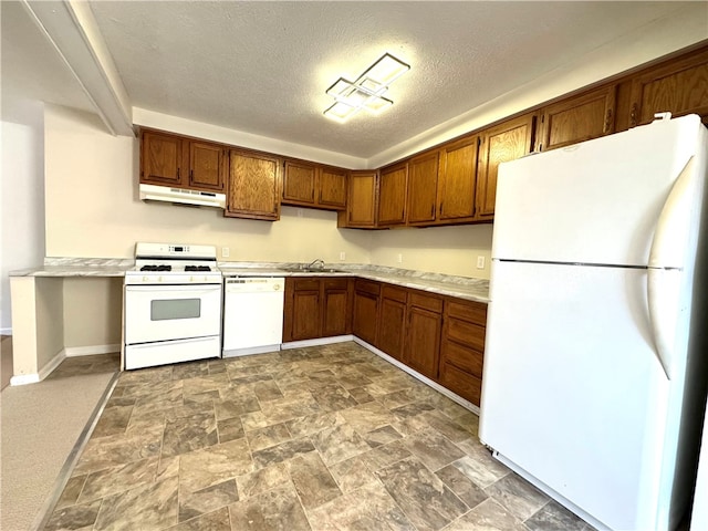 kitchen featuring a textured ceiling, white appliances, and sink