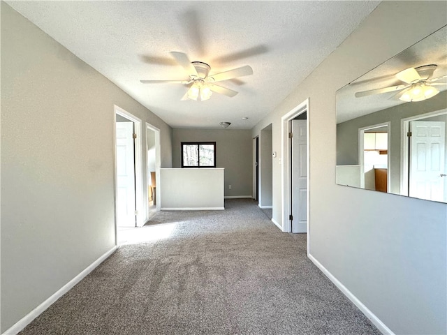 spare room featuring carpet, ceiling fan, and a textured ceiling