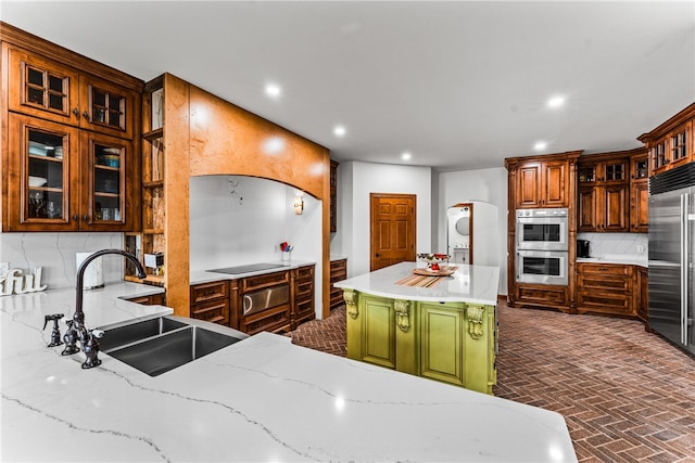 kitchen with a center island, sink, backsplash, stacked washer and clothes dryer, and appliances with stainless steel finishes