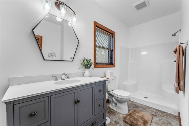 bathroom with vanity, toilet, and a shower