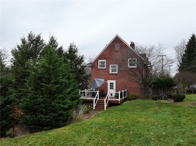 rear view of house with a deck and a yard