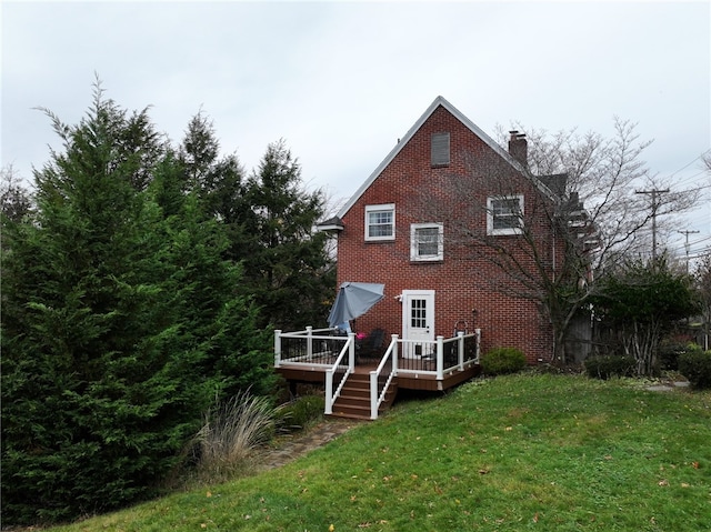 back of property featuring a lawn and a wooden deck