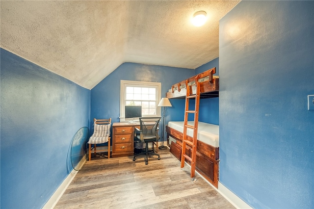 office space with lofted ceiling, wood-type flooring, and a textured ceiling