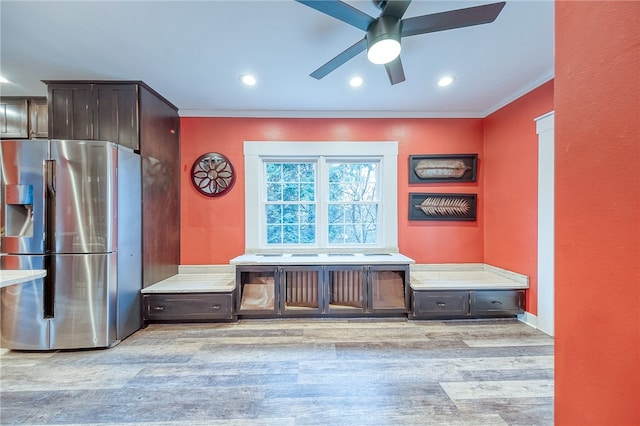 interior space featuring stainless steel refrigerator with ice dispenser, light hardwood / wood-style flooring, dark brown cabinets, and crown molding