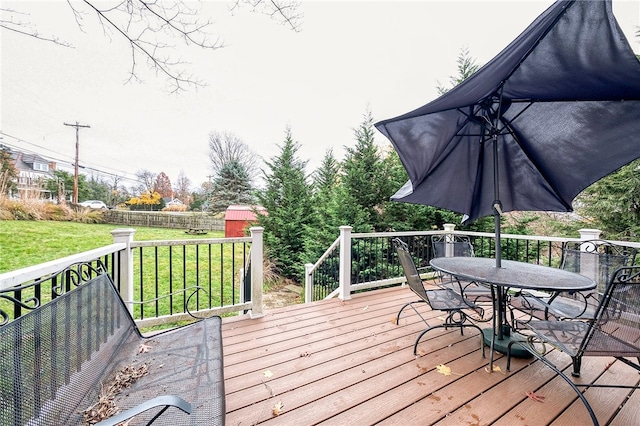 wooden deck featuring a shed and a yard