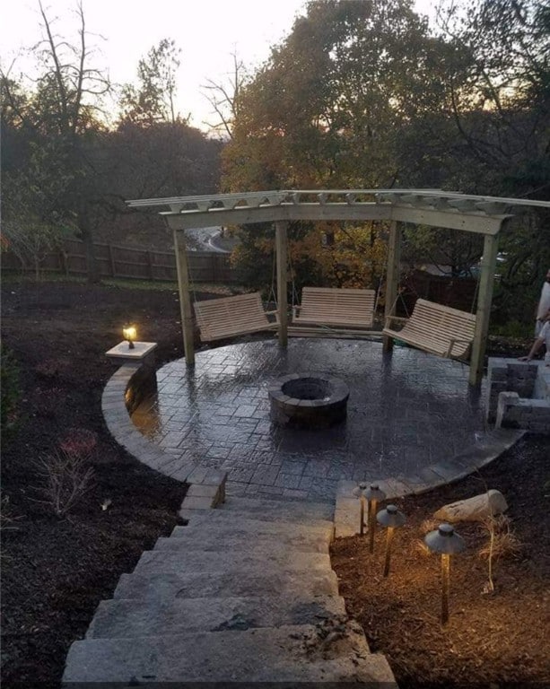 patio terrace at dusk featuring a fire pit