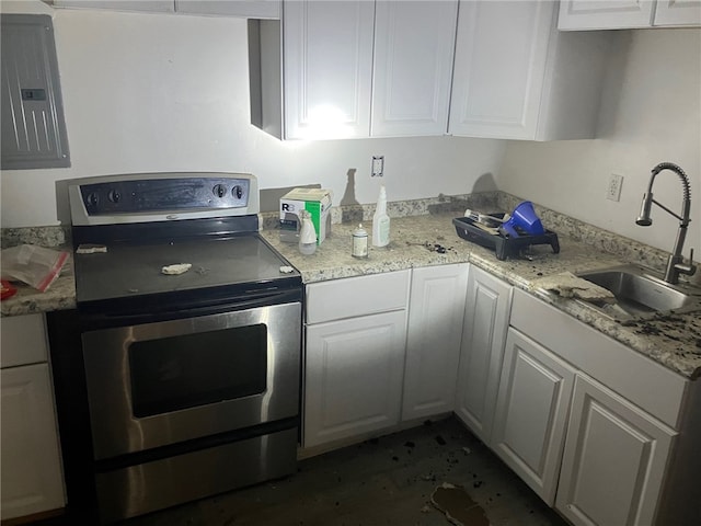 kitchen featuring stainless steel electric stove, electric panel, sink, and white cabinets