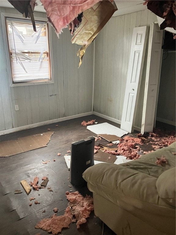 bonus room with wood-type flooring and wood walls