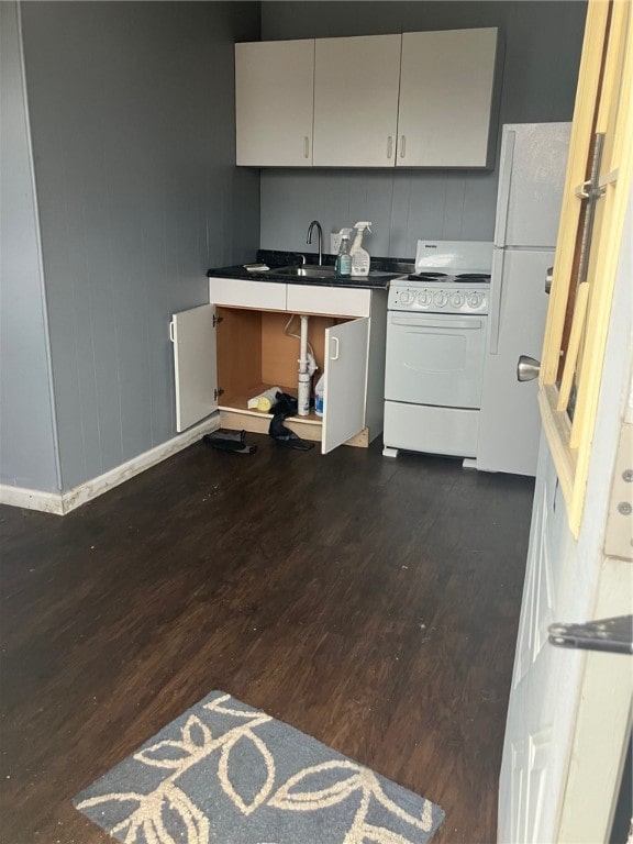 kitchen featuring white appliances, dark wood-type flooring, and sink