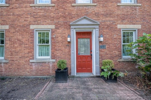 view of exterior entry with a patio area