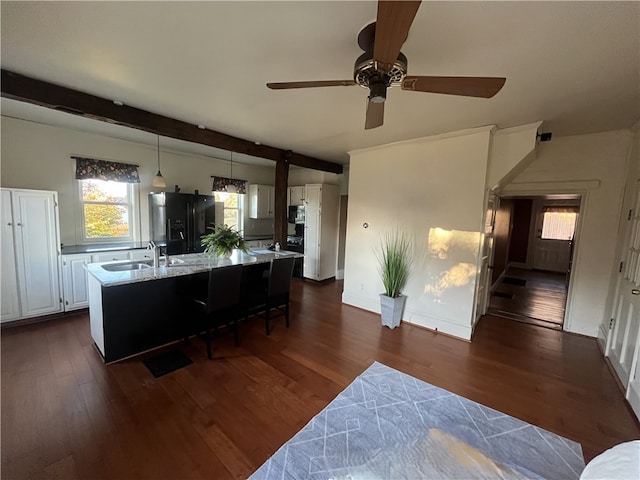 kitchen with white cabinets, dark hardwood / wood-style floors, black fridge with ice dispenser, and sink