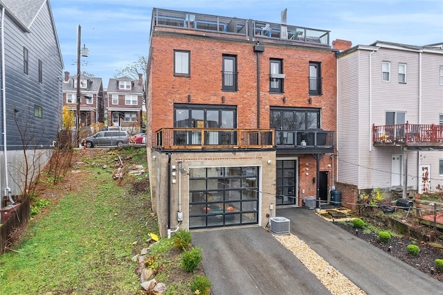 view of front of home featuring a balcony and central AC