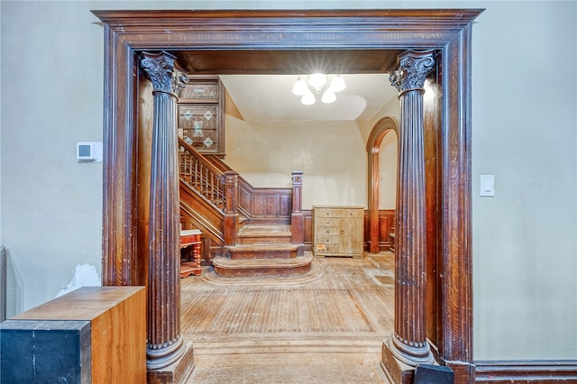 hallway with a chandelier and ornate columns